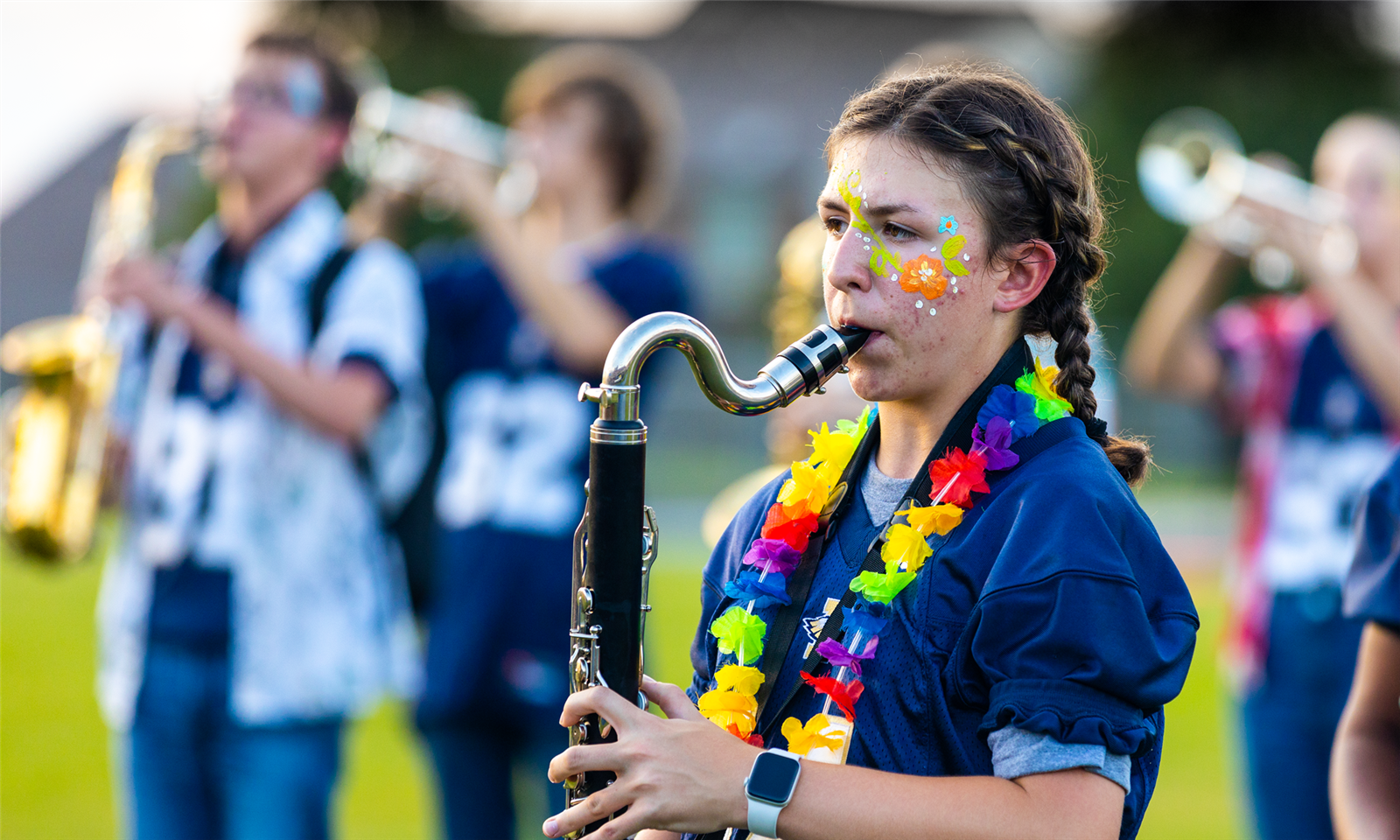 A girl plays an instrument on a football field